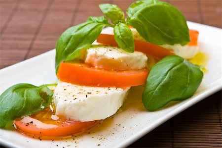 simsearch:400-05337090,k - Slices of tomato and mozzarella with pepper, olive oil and mint Foto de stock - Royalty-Free Super Valor e Assinatura, Número: 400-04546124