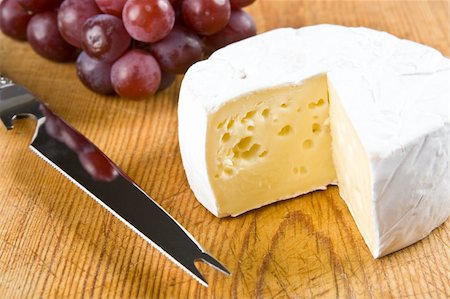 Segment of brie with grapes and a knife on a board Stock Photo - Budget Royalty-Free & Subscription, Code: 400-04546466