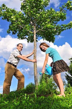 Father and daughter watering a young tree Foto de stock - Super Valor sin royalties y Suscripción, Código: 400-04546828