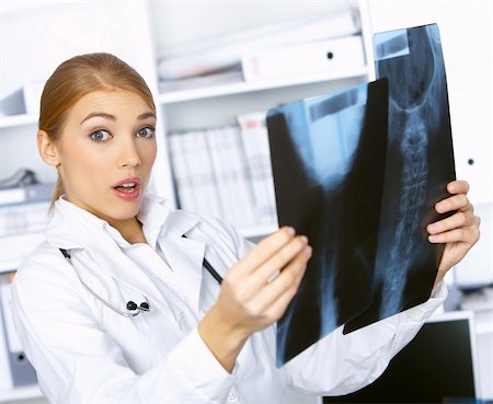 doctor examining confused - Portrait of confused female doctor examining x-ray picture Stock Photo - Budget Royalty-Free & Subscription, Code: 400-04549525