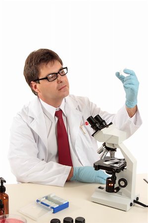 simsearch:400-05670478,k - A scientist, forensic investigator,  medical worker  or laboratory researcher inspecting prepared slides under a microscope. Stock Photo - Budget Royalty-Free & Subscription, Code: 400-04549860