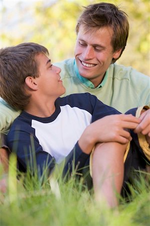 simsearch:400-04042848,k - Man and young boy sitting outdoors smiling Fotografie stock - Microstock e Abbonamento, Codice: 400-04540084