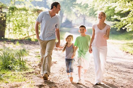 simsearch:400-04042848,k - Family running outdoors holding hands and smiling Fotografie stock - Microstock e Abbonamento, Codice: 400-04540085