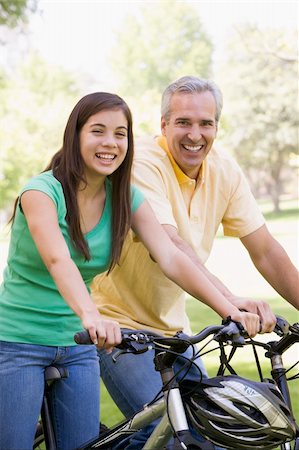 simsearch:400-04402106,k - Man and girl on bikes outdoors smiling Fotografie stock - Microstock e Abbonamento, Codice: 400-04540086