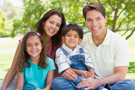 simsearch:400-04042848,k - Family sitting outdoors smiling Fotografie stock - Microstock e Abbonamento, Codice: 400-04540087