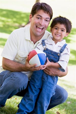 simsearch:400-04042848,k - Man and young boy outdoors with football smiling Fotografie stock - Microstock e Abbonamento, Codice: 400-04540088