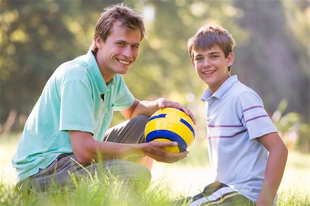 simsearch:400-04042848,k - Man and young boy outdoors with soccer ball smiling Fotografie stock - Microstock e Abbonamento, Codice: 400-04540083