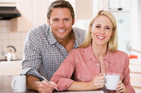 studying drinking coffee - Couple in kitchen with newspaper and coffee smiling Stock Photo - Budget Royalty-Free & Subscription, Code: 400-04540407