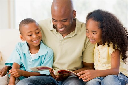Man and two children sitting in living room reading book and smi Stock Photo - Budget Royalty-Free & Subscription, Code: 400-04540415