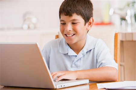 simsearch:400-04044137,k - Young boy in kitchen with laptop and paperwork smiling Stock Photo - Budget Royalty-Free & Subscription, Code: 400-04540524