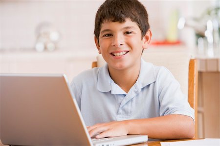 simsearch:400-04044122,k - Young boy in kitchen with laptop and paperwork smiling Stock Photo - Budget Royalty-Free & Subscription, Code: 400-04540525