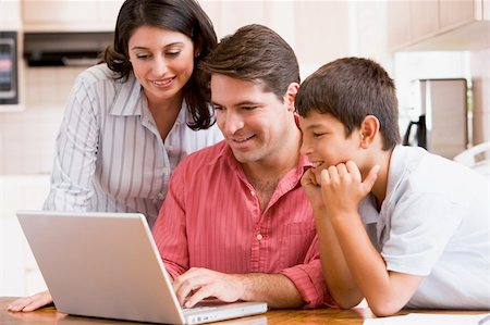 simsearch:400-04044108,k - Family in kitchen with laptop smiling Stock Photo - Budget Royalty-Free & Subscription, Code: 400-04540529