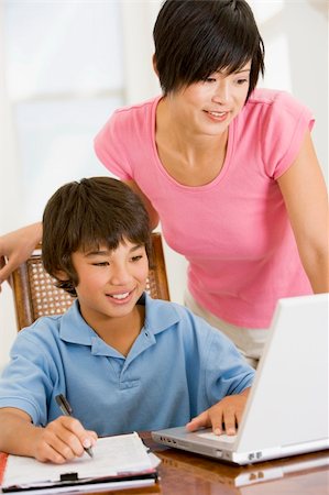 Woman helping young boy with laptop do homework in dining room s Stock Photo - Budget Royalty-Free & Subscription, Code: 400-04540534