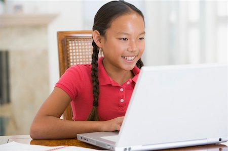 simsearch:400-04044137,k - Young girl with laptop in dining room smiling Stock Photo - Budget Royalty-Free & Subscription, Code: 400-04540533