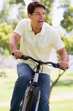 simsearch:400-04402100,k - Man outdoors riding bike smiling Stock Photo - Budget Royalty-Free & Subscription, Code: 400-04540753