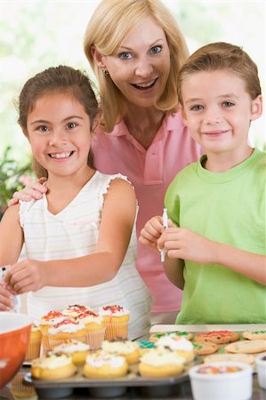 parents and children and cupcakes - Woman with two children in kitchen decorating cookies smiling Stock Photo - Budget Royalty-Free & Subscription, Code: 400-04540785