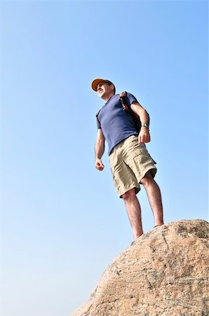simsearch:400-08506088,k - Middle aged hiker standing on top of a mountain Fotografie stock - Microstock e Abbonamento, Codice: 400-04540825