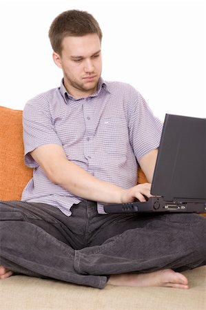 simsearch:400-04999709,k - casual guy sitting on sofa with laptop Photographie de stock - Aubaine LD & Abonnement, Code: 400-04540856