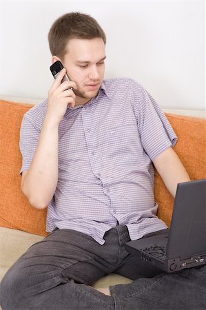 simsearch:400-04999709,k - casual guy sitting on sofa with laptop Photographie de stock - Aubaine LD & Abonnement, Code: 400-04540894