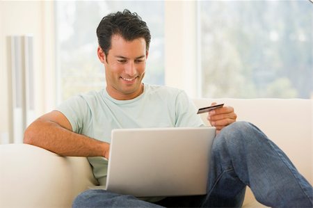 simsearch:400-05000471,k - Man in living room using laptop and holding credit card smiling Foto de stock - Royalty-Free Super Valor e Assinatura, Número: 400-04540991