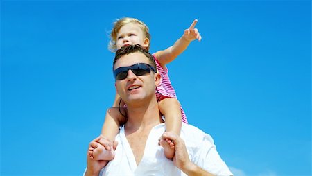 daughter riding on dads shoulders - view of young family hanging out in summer environment. Stock Photo - Budget Royalty-Free & Subscription, Code: 400-04541627