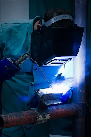 Welder working in the blue light of his torch. Stock Photo - Budget Royalty-Free & Subscription, Code: 400-04541686