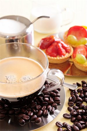pictures of coffee beans and berry - Freshly brewed coffee with a selection of pastries and cakes. Coffee beans are scattered for extra effect. Foto de stock - Super Valor sin royalties y Suscripción, Código: 400-04542323