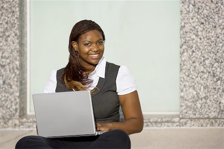 Pretty African American woman on sidealk with laptop computer Stock Photo - Budget Royalty-Free & Subscription, Code: 400-04543317