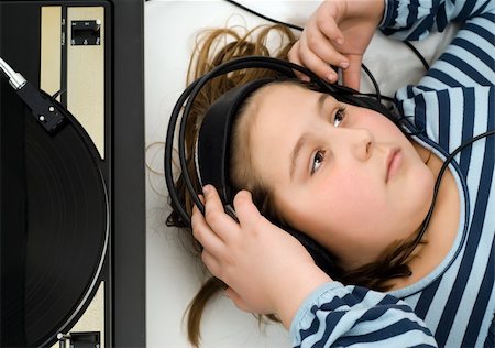 record player and girl - Girl lying on the floor listening to music from an old record player Stock Photo - Budget Royalty-Free & Subscription, Code: 400-04554343