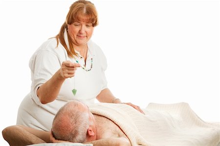 pendolo - New age healer using a jade pendulum to unblock her patient's energy centers. Fotografie stock - Microstock e Abbonamento, Codice: 400-04554869