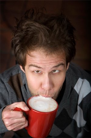 simsearch:400-04554624,k - Young man drinking speialty coffee drink from red mug Stock Photo - Budget Royalty-Free & Subscription, Code: 400-04555610