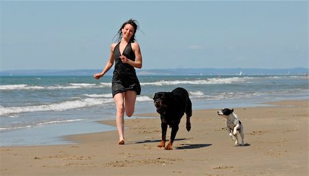 running rottweiler - woman and her two dogs running on the beach Stock Photo - Budget Royalty-Free & Subscription, Code: 400-04558453