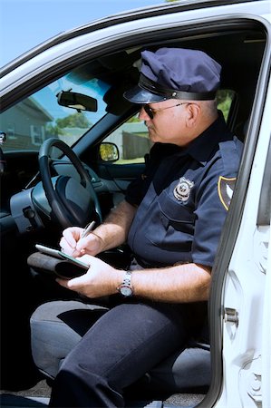 simsearch:693-03782773,k - Police officer sitting in his squad car writing a citation. Stockbilder - Microstock & Abonnement, Bildnummer: 400-04559280