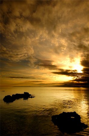 simsearch:400-09011314,k - Spectacular golden sunset over silhouetted sea rocks. Room for text on top. Stockbilder - Microstock & Abonnement, Bildnummer: 400-04550630