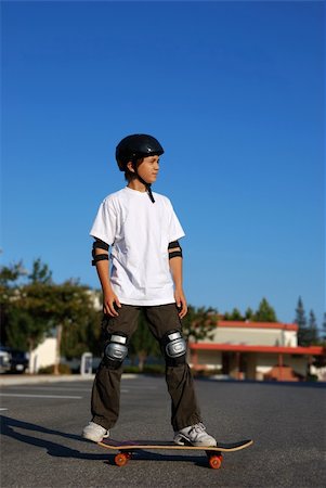 simsearch:400-05308347,k - boy standing on a skateboard in an afternoon sun with blue sky in the background Stock Photo - Budget Royalty-Free & Subscription, Code: 400-04551849