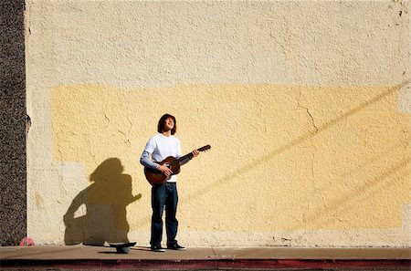 Young man on street with guitar and hat Stock Photo - Budget Royalty-Free & Subscription, Code: 400-04551959