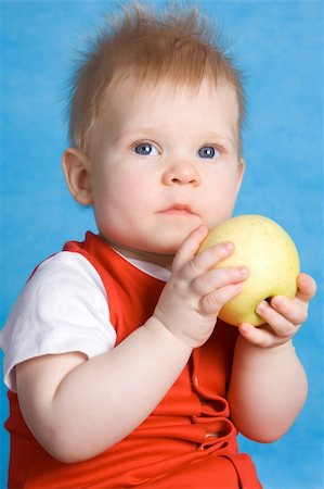 simsearch:400-05014700,k - Baby boy eating an apple isolated on a blue background Fotografie stock - Microstock e Abbonamento, Codice: 400-04552229