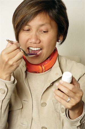 sick woman take care - An Asian female in her early 40's taking a spoonful of cough medicine. Stock Photo - Budget Royalty-Free & Subscription, Code: 400-04552433