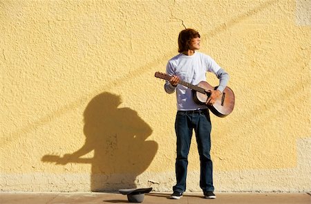 Young male musician alone on the sidewalk with guitar Stock Photo - Budget Royalty-Free & Subscription, Code: 400-04552890