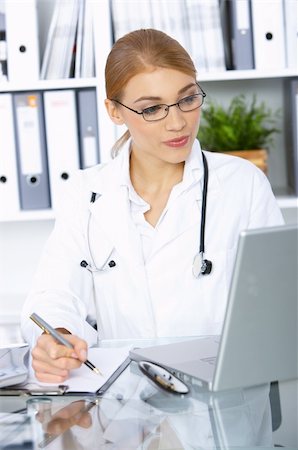 simsearch:400-04178933,k - Smiling female doctor writing notes in clipboard Stock Photo - Budget Royalty-Free & Subscription, Code: 400-04553542