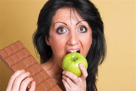 simsearch:400-05014700,k - Woman choosing a apple over chocolate Fotografie stock - Microstock e Abbonamento, Codice: 400-04564127