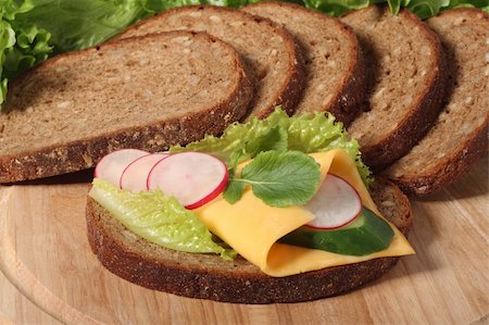 Sandwich with cheese and vegetables and bread slices on cutboard Stock Photo - Budget Royalty-Free & Subscription, Code: 400-04564292