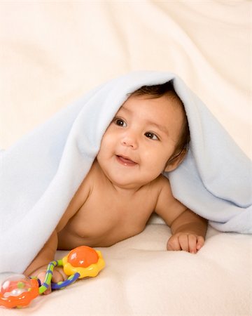 cute kid lying down on his tummy on blanket with stuck out tongue playing peek-a-boo Stock Photo - Budget Royalty-Free & Subscription, Code: 400-04566808