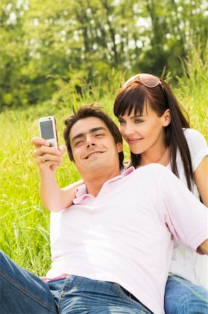 simsearch:400-04059847,k - Young couple outdoors, woman taking photo with mobile phone Stockbilder - Microstock & Abonnement, Bildnummer: 400-04567263