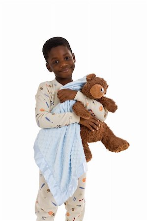 Young African American boy wearing pajamas and holding a blue blanket and a well-loved teddy bear. Isolated on a white background. Foto de stock - Royalty-Free Super Valor e Assinatura, Número: 400-04567280