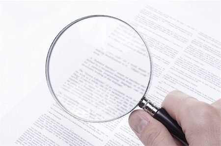 Confusing legal fine print on a business contract rendered blurred even with the aid of a magnifying glass. Stockbilder - Microstock & Abonnement, Bildnummer: 400-04567824