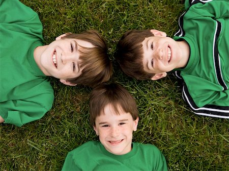 simsearch:400-05166871,k - Three Brothers in Green Laying in the Grass Foto de stock - Royalty-Free Super Valor e Assinatura, Número: 400-04568554