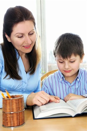 students working at library table - Teacher or tutor helping school boy to study Stock Photo - Budget Royalty-Free & Subscription, Code: 400-04560081