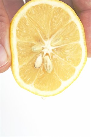 hand squeezing lemon isolated against white background Foto de stock - Royalty-Free Super Valor e Assinatura, Número: 400-04561776
