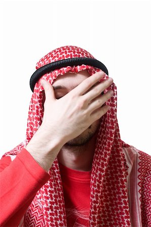 simsearch:614-02764094,k - Portrait of an arabian young man in traditional headscarf - shemagh. He closed his face by hand palm. Stockbilder - Microstock & Abonnement, Bildnummer: 400-04562269